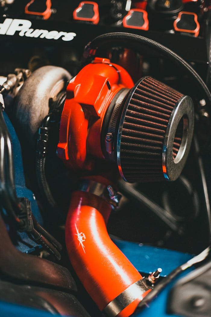 Detailed close-up of a car engine featuring a vibrant red turbocharger and air filter.